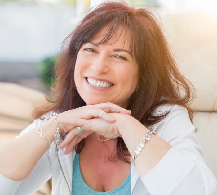 Smiling brunette woman resting her chin in her hands