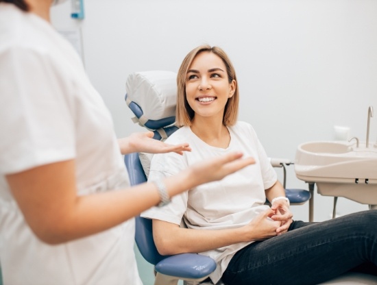Woman in dental chair listening to her dentist