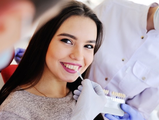 Woman smiling while being fitted for veneers by her cosmetic dentist in Rocky Hill