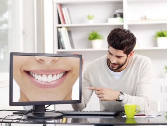 Man pointing to computer screen showing smile with flawless teeth