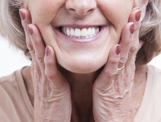 Smiling senior woman touching her face