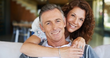 Woman hugging man from behind and smiling