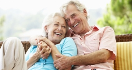 Elderly couple cuddling on couch