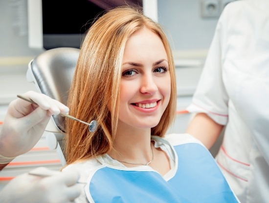 Blonde woman smiling during preventive dentistry checkup