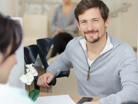 Man smiling at receptionist at front desk