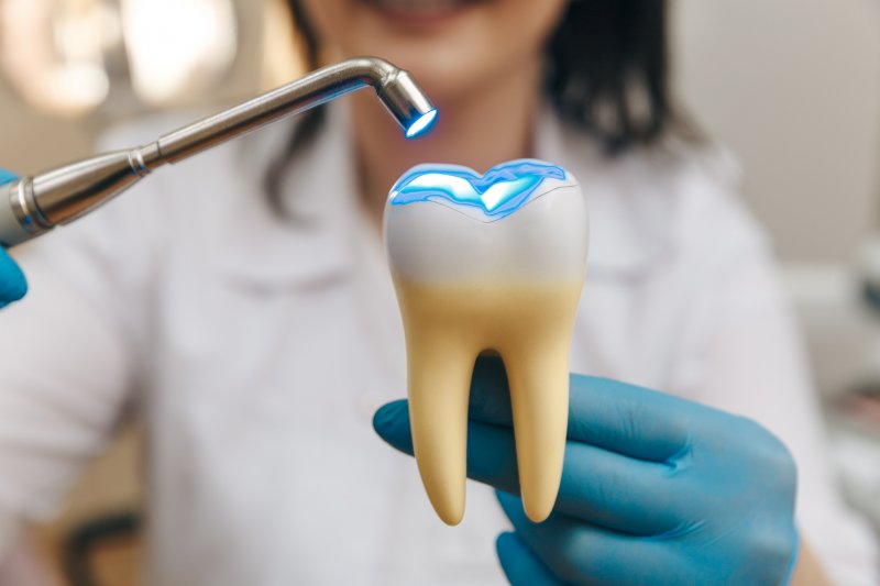 Dentist holding a model of an amalgam filling